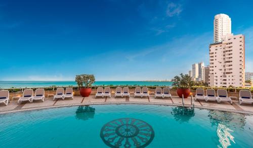 卡塔赫纳哥伦比亚卡塔赫纳阿尔米兰特酒店的一个带躺椅的游泳池和海洋