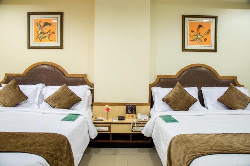 塞恩Hotel Tip Top Plaza的酒店客房设有两张床和一张桌子。