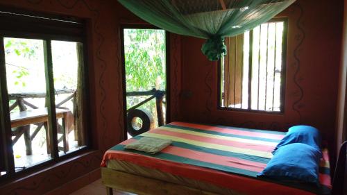 阿鲁甘湾Beach Hut的一间卧室设有一张床和两个窗户。