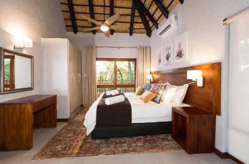 雾观Kruger Park Lodge Unit No. 611的一间卧室配有一张大床和镜子