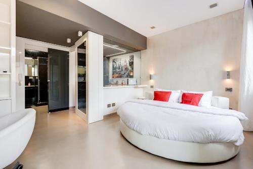 罗马EMERALD Luxury Suite Apartment的一间白色的大卧室,配有一张带红色枕头的大床