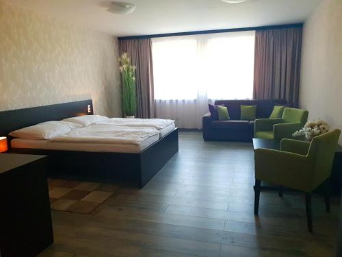 Lednické RovneKMK Penzión的一间卧室配有一张床、两把椅子和一张沙发