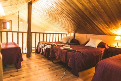 塔韦尔纳斯Camping Fort Bravo的客房设有三张床和木制天花板。