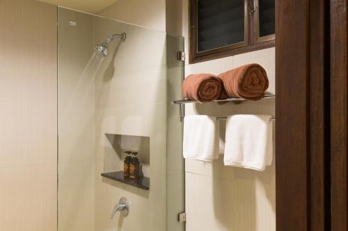 查汶J4 Samui Hotel - SHA Plus的带淋浴和白色毛巾的浴室