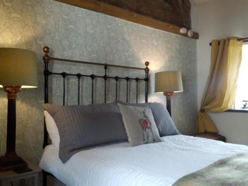 里辛Castle Street Cottage的一间卧室配有一张带白色床单和两盏灯的床。