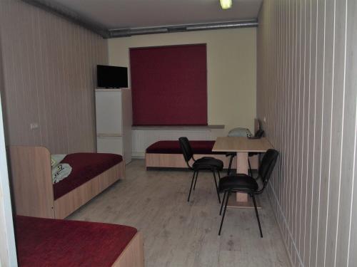 考纳斯Hostelis Laurita的小房间设有一张床、一张桌子和椅子
