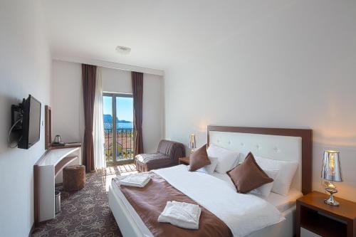 布德瓦Hotel Pozzo的配有一张床和一把椅子的酒店客房