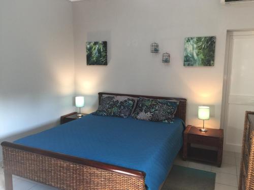 阿尔布费拉阿瓜维瓦公寓的一间卧室配有一张带蓝色床单的床和两盏灯。