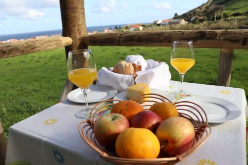 圣克鲁什达什弗洛里什Casas da Quinta的桌上一篮苹果和橙子,配以酒杯