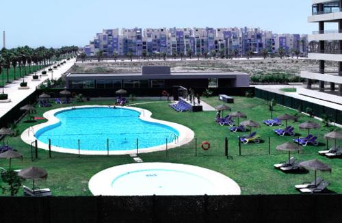 滨海罗克塔斯Residencial Mirador Playa Serena的度假村内带椅子和遮阳伞的游泳池