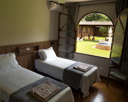 马林加Hostel SLG的客房设有两张床、一把椅子和窗户。