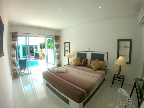 拉迈Wirason pool Villa 4 bedrooms的一间带大床的卧室和一个阳台