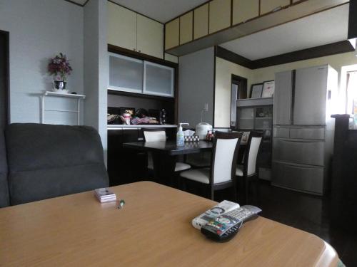 平泉町Minpaku Suzuki的厨房以及带2个遥控器的桌子的用餐室
