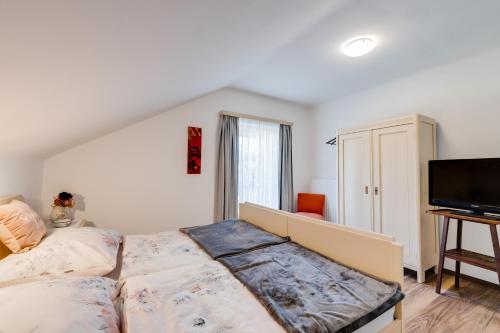玛利亚采尔Gerli Appartement Mariazell的一间卧室配有一张床和一台平面电视