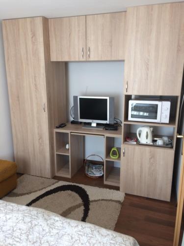 维谢格拉德Liliom Vendégház的客房设有电视和带微波炉的书桌。
