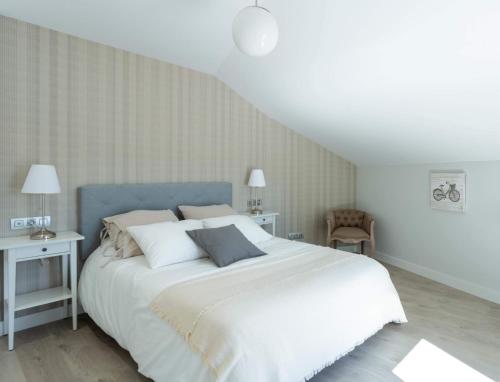 拉科鲁尼亚Indigo Rooftop的卧室配有一张带白色床单和枕头的大床。