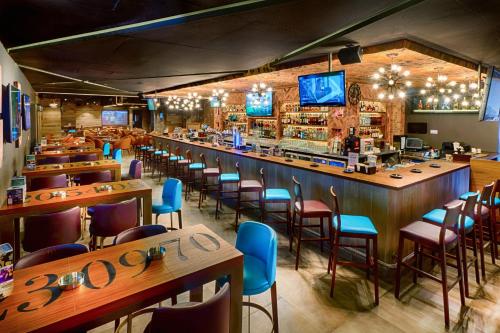迪拜布尔迪拜城市马克斯酒店的餐厅设有酒吧,配有木桌和椅子