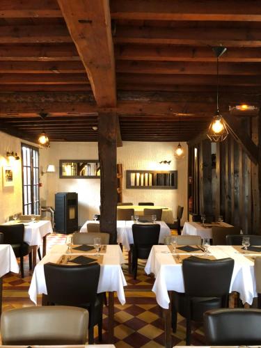 LinxeClos 85的餐厅设有白色的桌椅和木制天花板。