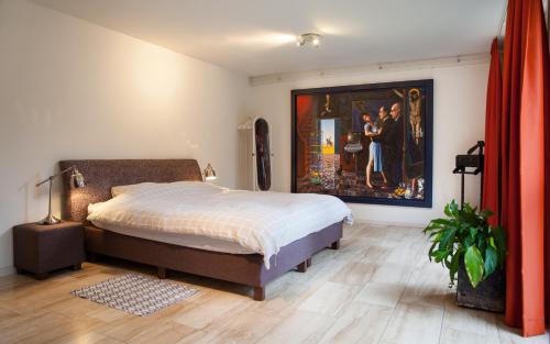 格罗宁根Suite 30 - kingsize groundfloor hotelapartment with parking的卧室配有一张床,墙上挂有绘画作品