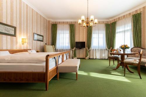 菲尔斯滕费尔德布鲁克祖尔帕斯特罗曼蒂克酒店的酒店客房带一张床、一张桌子和椅子