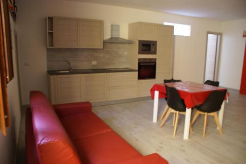 卡拉古诺内casa mariolu 2的客厅配有红色的沙发、桌子和椅子