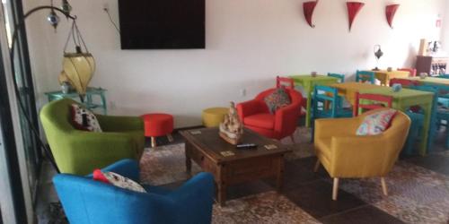 德尔迪阿布罗角El Bodegón Hostal Boutique的客厅配有五颜六色的椅子和桌子