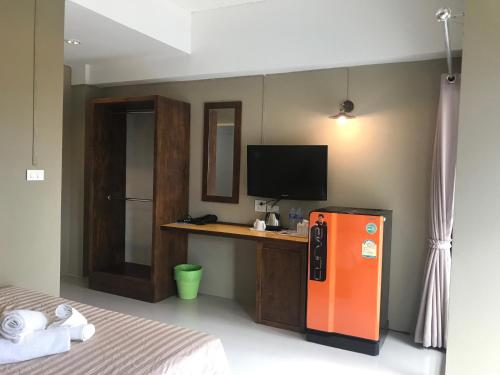 柴老海滩Baan Ton Chan的一间卧室配有橙色冰箱和书桌