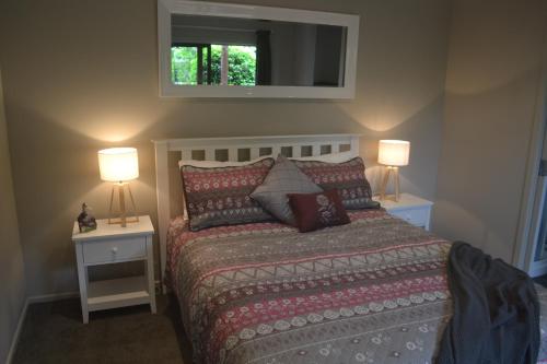 奥玛鲁Highlands on Homestead的一间卧室配有一张带2个床头柜和2盏灯的床。