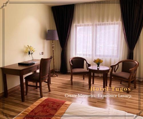 碧瑶Hotel Tugos的客房设有桌椅和窗户。