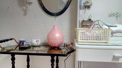八王子市宫古日式旅馆的一张桌子,上面有粉红色的花瓶
