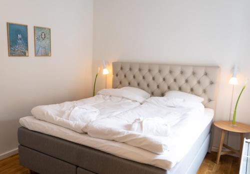 奥尔堡Mortens Kro Boutique Hotel的卧室内的一张带白色床单和枕头的床