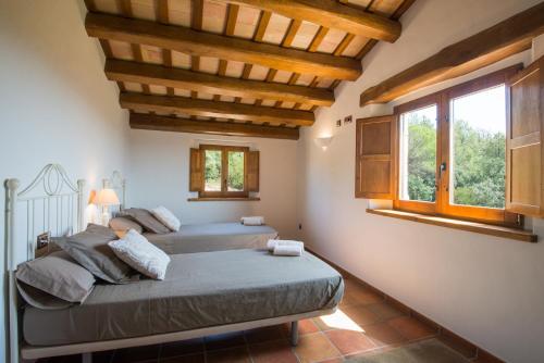 圣科洛马·德法尔Can Jan de Castanyet的一间卧室设有两张床和大窗户