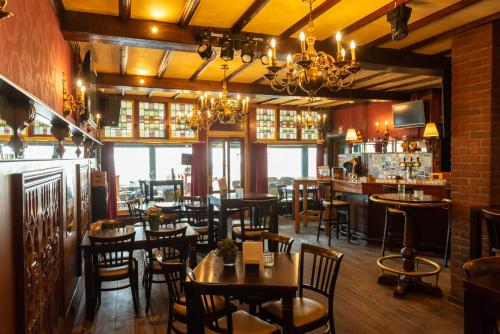 鲁尔蒙德德堡武豪华咖啡厅与酒店的一间带桌椅的餐厅和一间酒吧