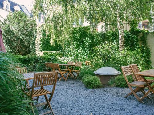 巴黎巴黎阿德维尼亚特旅舍的花园设有木椅、桌子和长椅