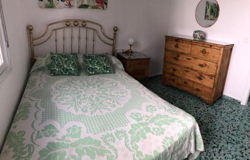 莫切El Balcón de Rosita的一间卧室配有一张大床和一个木制梳妆台