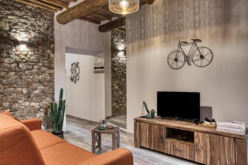基安蒂格雷夫Il Nido nel Chianti的客厅配有电视,墙上有自行车