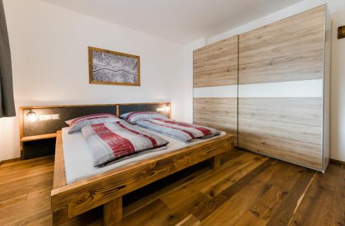 阿尔滕马克特蓬高Appartment Sorgenfrei的一间卧室配有一张带两个枕头的木床