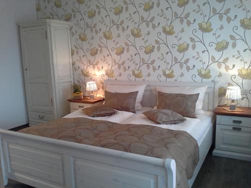 格拉登巴赫Gasthaus Hinterländer Schweiz的卧室配有白色床和花卉壁纸