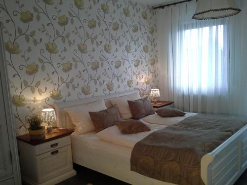 格拉登巴赫Gasthaus Hinterländer Schweiz的卧室配有一张墙上鲜花的大床