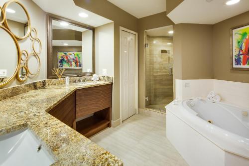迈尔斯堡海滩鸥翼海滩度假酒店的一间带大浴缸和大镜子的浴室
