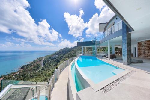 茶云莱海滩Villa Seawadee - luxurious, award-winning design Villa with amazing panoramic seaview的阳台享有海景,设有游泳池
