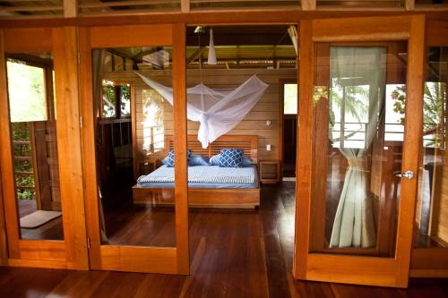 博卡斯德尔托罗Residencia Natural的一间卧室设有一张床和一个玻璃门