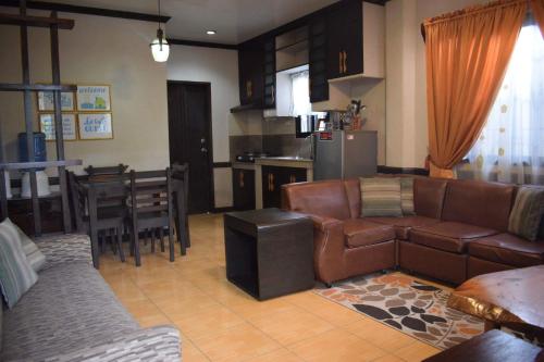 碧瑶JCGA Apartments (Angelo's Burnham)的带沙发和桌子的客厅以及厨房。