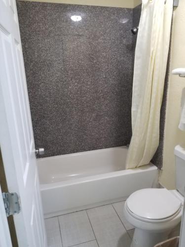 橙县Economy Inn Motel的浴室配有卫生间、浴缸和卫生间。