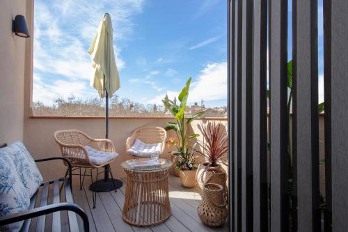 巴塞罗那绿洲酒店的阳台配有桌椅和雨伞。