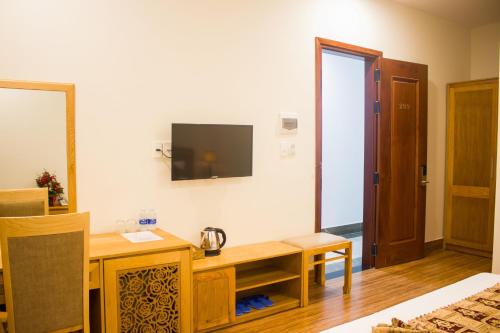 波来古市Hoài Thương Hotel的客房设有书桌和墙上的电视。
