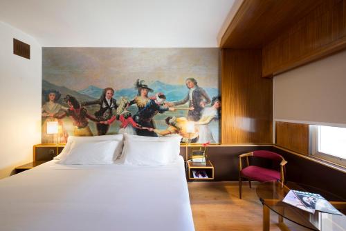 萨拉戈萨戈雅酒店的酒店客房设有一张床,墙上挂有绘画作品