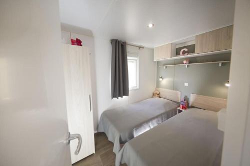 卡内·德·玛尔Camping Victoria的小房间设有两张床和窗户