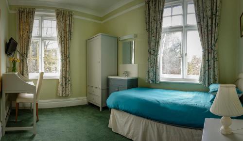 牛津Sandfield Guest House的一间卧室设有蓝色的床和2个窗户。