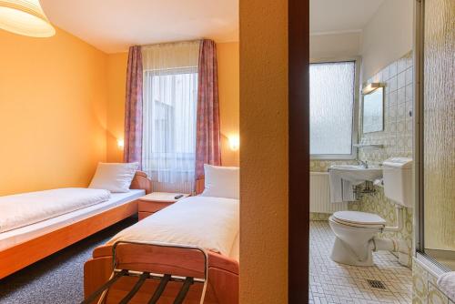 多特蒙德Hotel Carlton的酒店客房带两张床和一间浴室